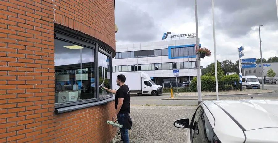 Radix-medewerker wast ramen aan de buitenzijde van een pand